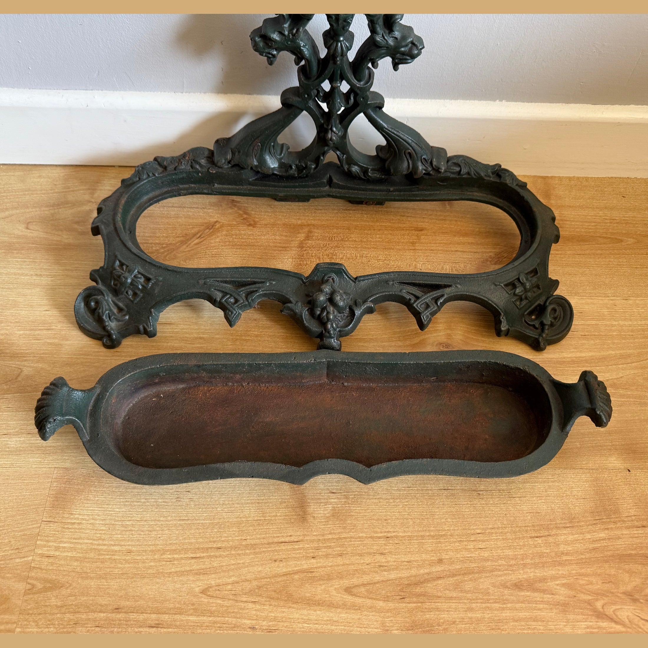 Detachable tray and ornate base of dark green cast iron stick stand